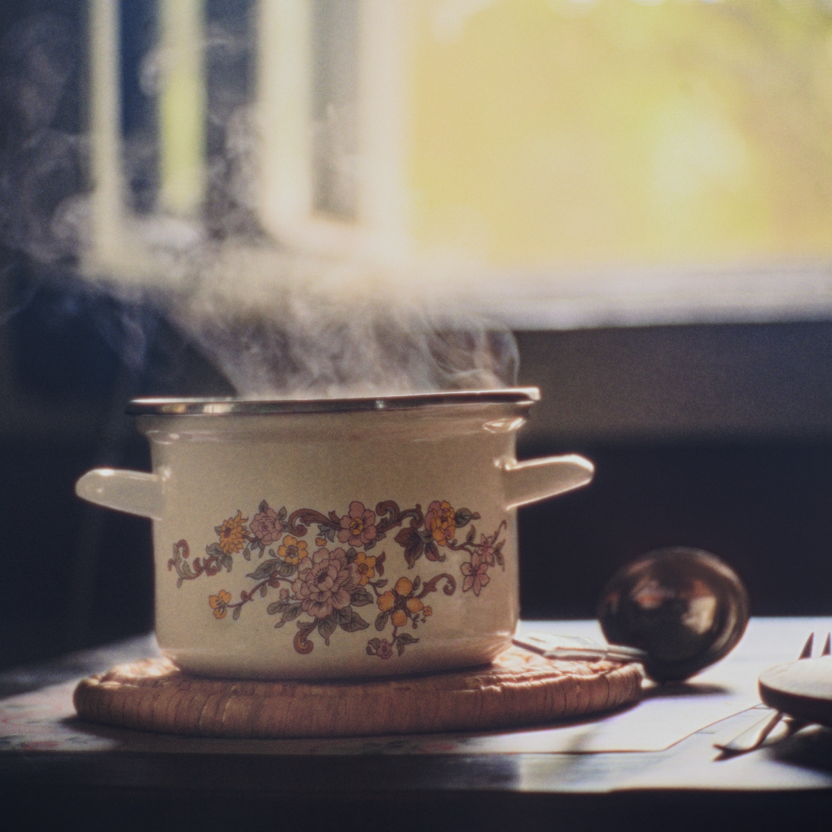 Casserole fumante posée sur une table rustique, plat du jour maison prêt à emporter