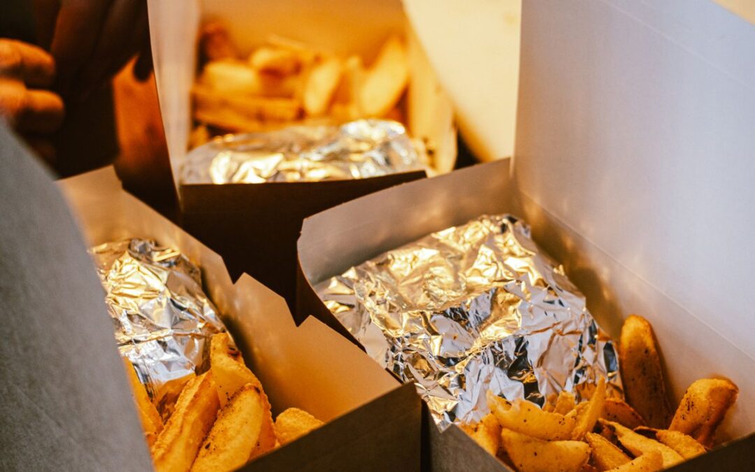 Plats chauds à emporter avec frites emballés dans des boîtes en carton prêts à récupérer