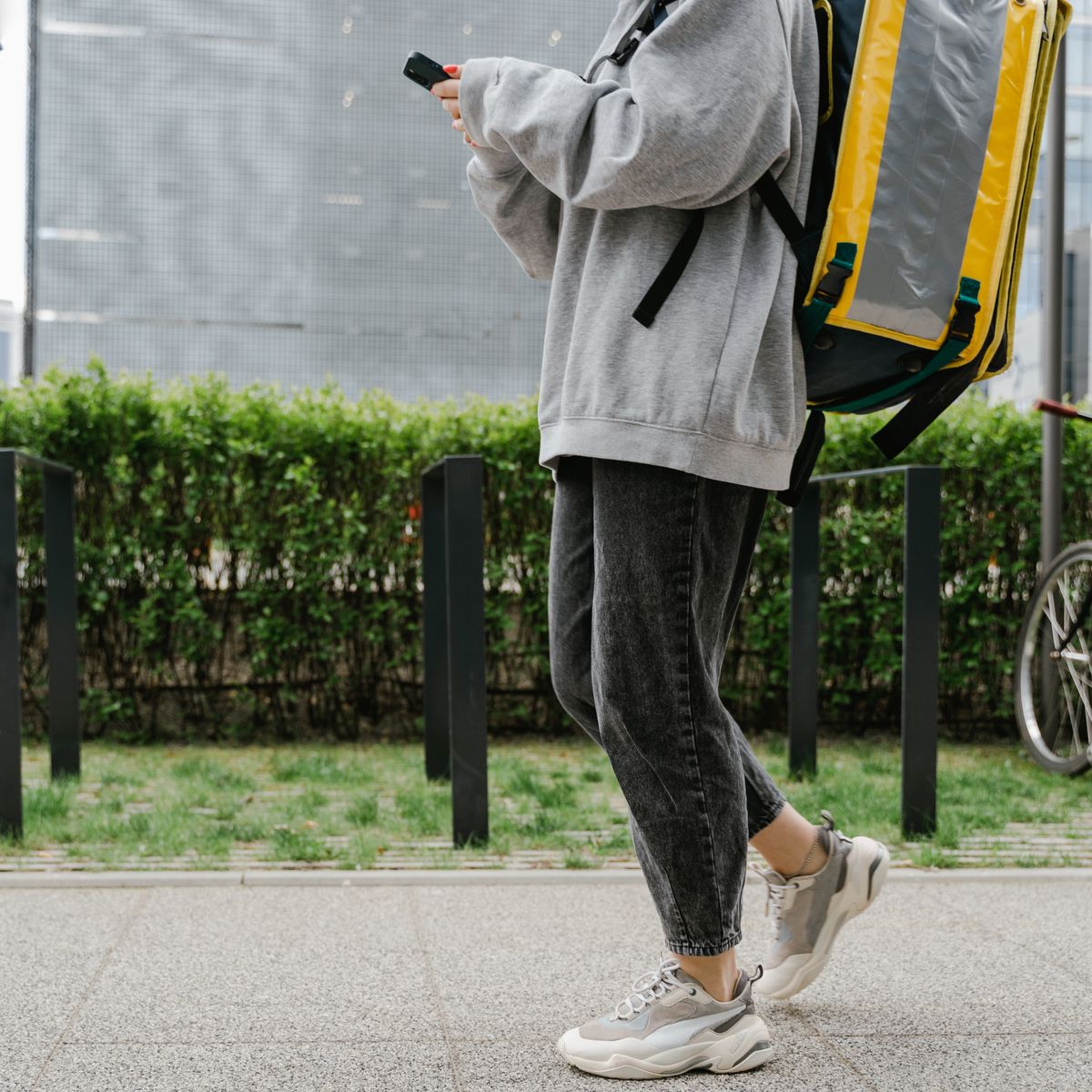 Livreur avec sac à dos thermique en déplacement, illustrant la livraison de plats à emporter
